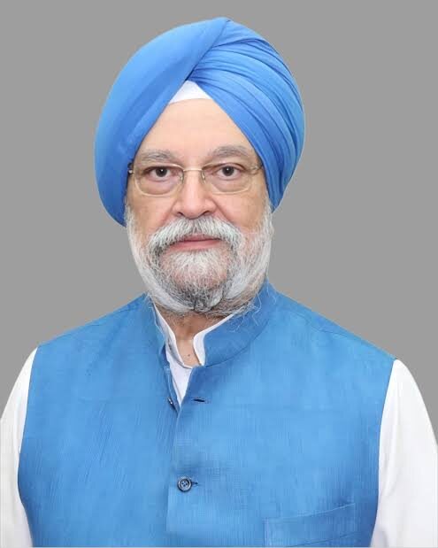 Official-style portrait of Hardeep Singh Puri in a blue turban and blue bandhgala waistcoat against a grey background
