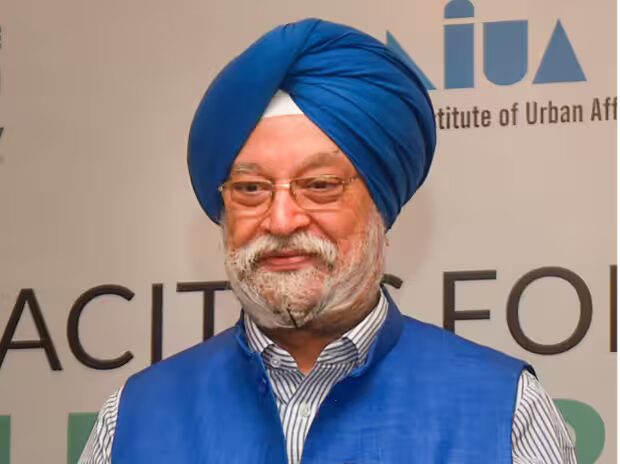Hardeep Singh Puri in a blue turban and waistcoat in front of a National Institute of Urban Affairs backdrop