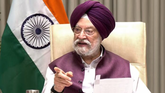 Hardeep Singh Puri in a purple turban gesturing while chairing a meeting