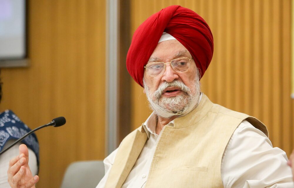 Hardeep Singh Puri in a red turban and cream waistcoat speaking at a roundtable