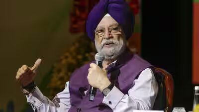 Hardeep Singh Puri in a purple turban speaking into a microphone on stage