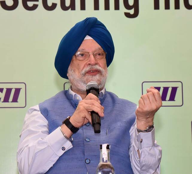 Hardeep Singh Puri in a blue turban speaking into a microphone at a CII event